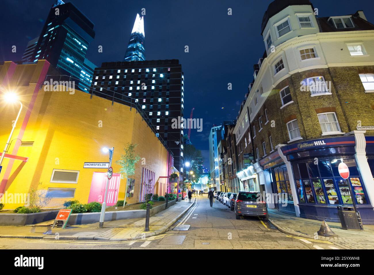 Vue nocturne de Snowfields, Londres, Royaume-Uni. Le Shard et les bâtiments environnants sont visibles. Voitures garées dans une rue étroite. Un magasin de Paris William Hill Banque D'Images