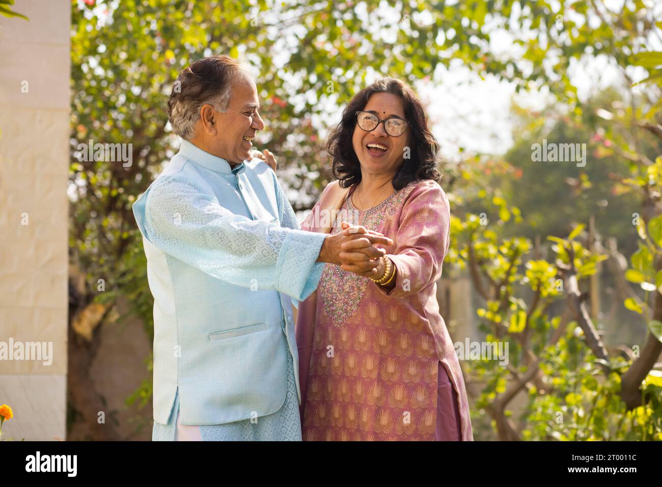 Portrait de couple heureux dansant ensemble dans le jardin Banque D'Images