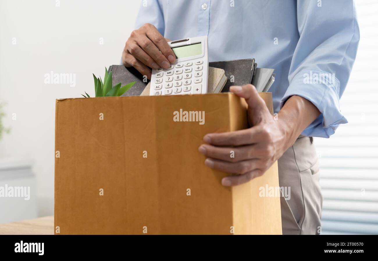 Homme d'affaires envoyant la lettre de démission et l'emballage des trucs démissionner dépriment ou portant la boîte en carton d'affaires par le bureau dans le bureau. C Banque D'Images