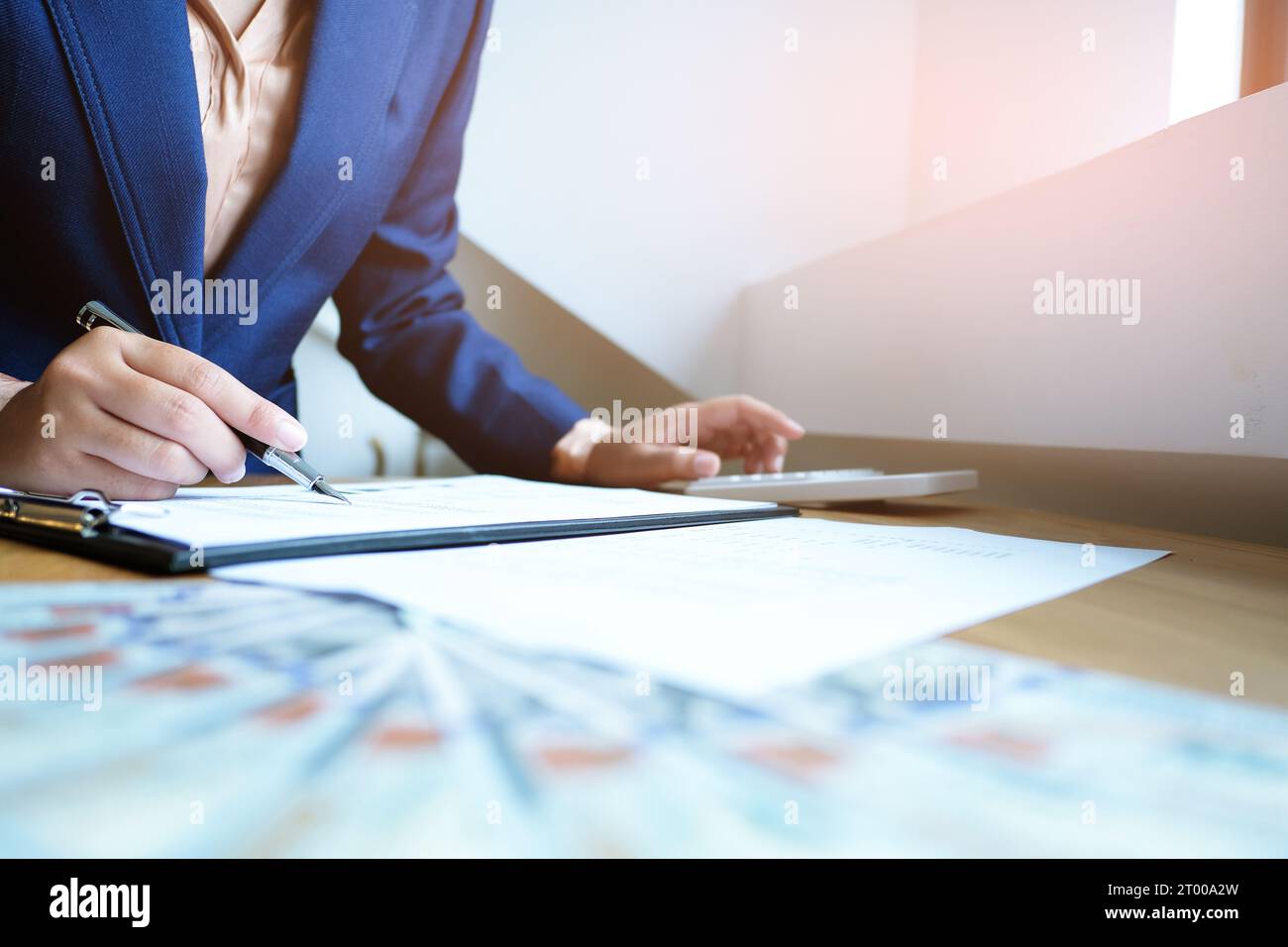 Homme d'affaires analysant les graphiques d'investissement et appuyant sur les boutons de la calculatrice au-dessus des documents.Concept comptable. Banque D'Images