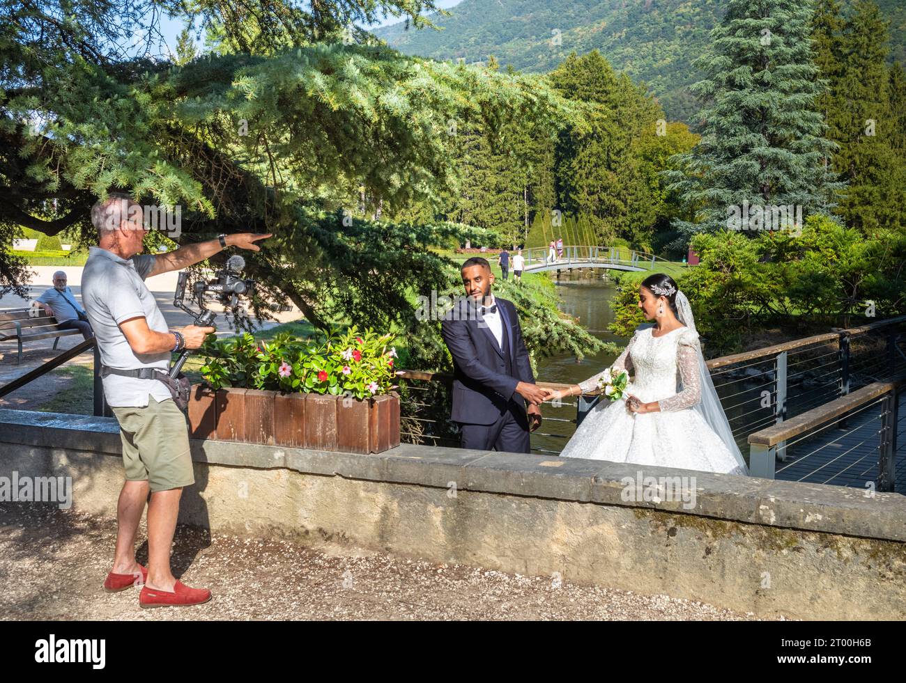 Un photographe de mariage dirige un couple musulman nouvellement marié pour des photos dans le parc du château abritant le Musée de la Révolution française, Vizill Banque D'Images