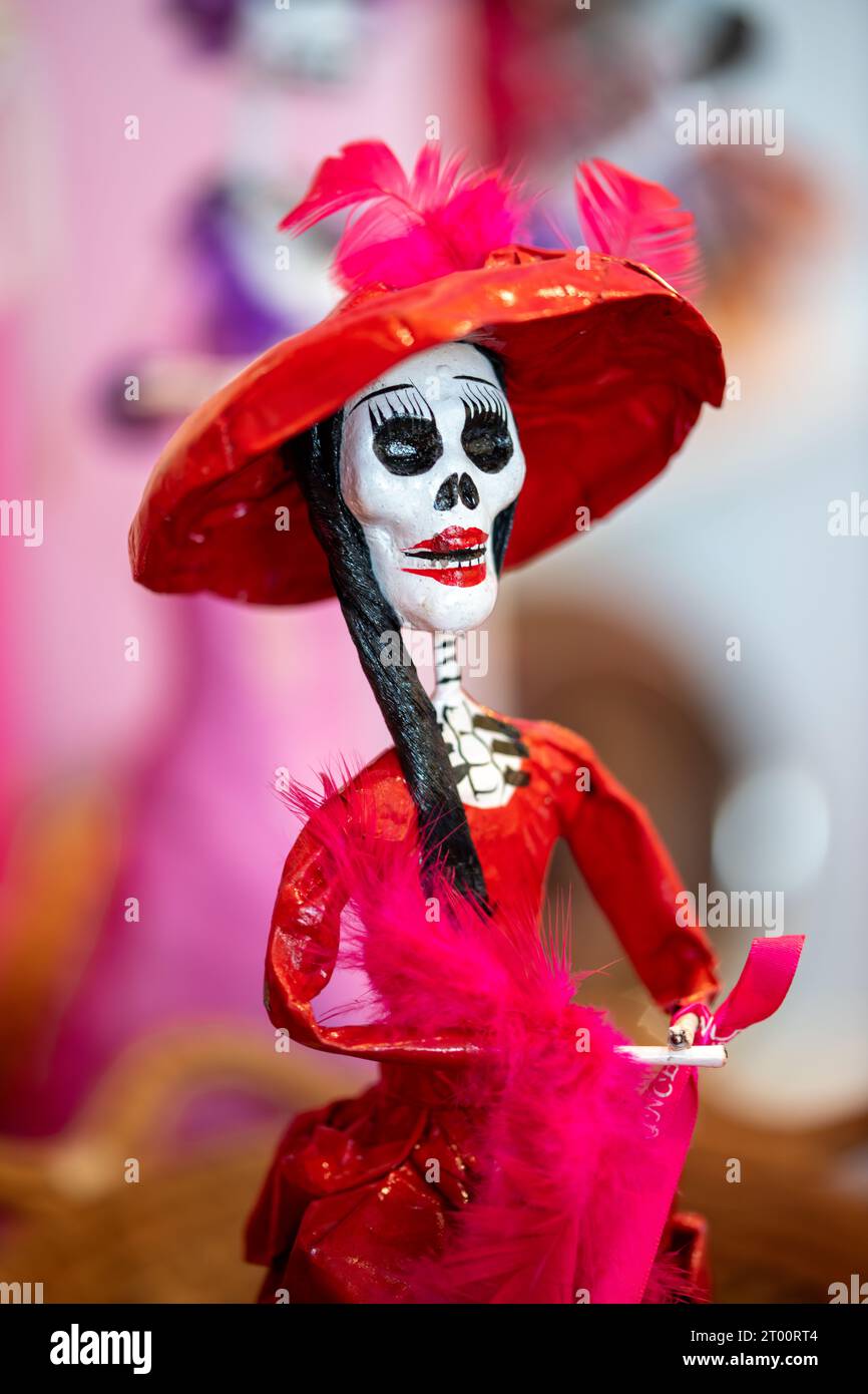 Une petite figure représentant un squelette vêtu d'une robe rouge et d'un chapeau rouge, semblable aux figures du Dias de los muertos Banque D'Images