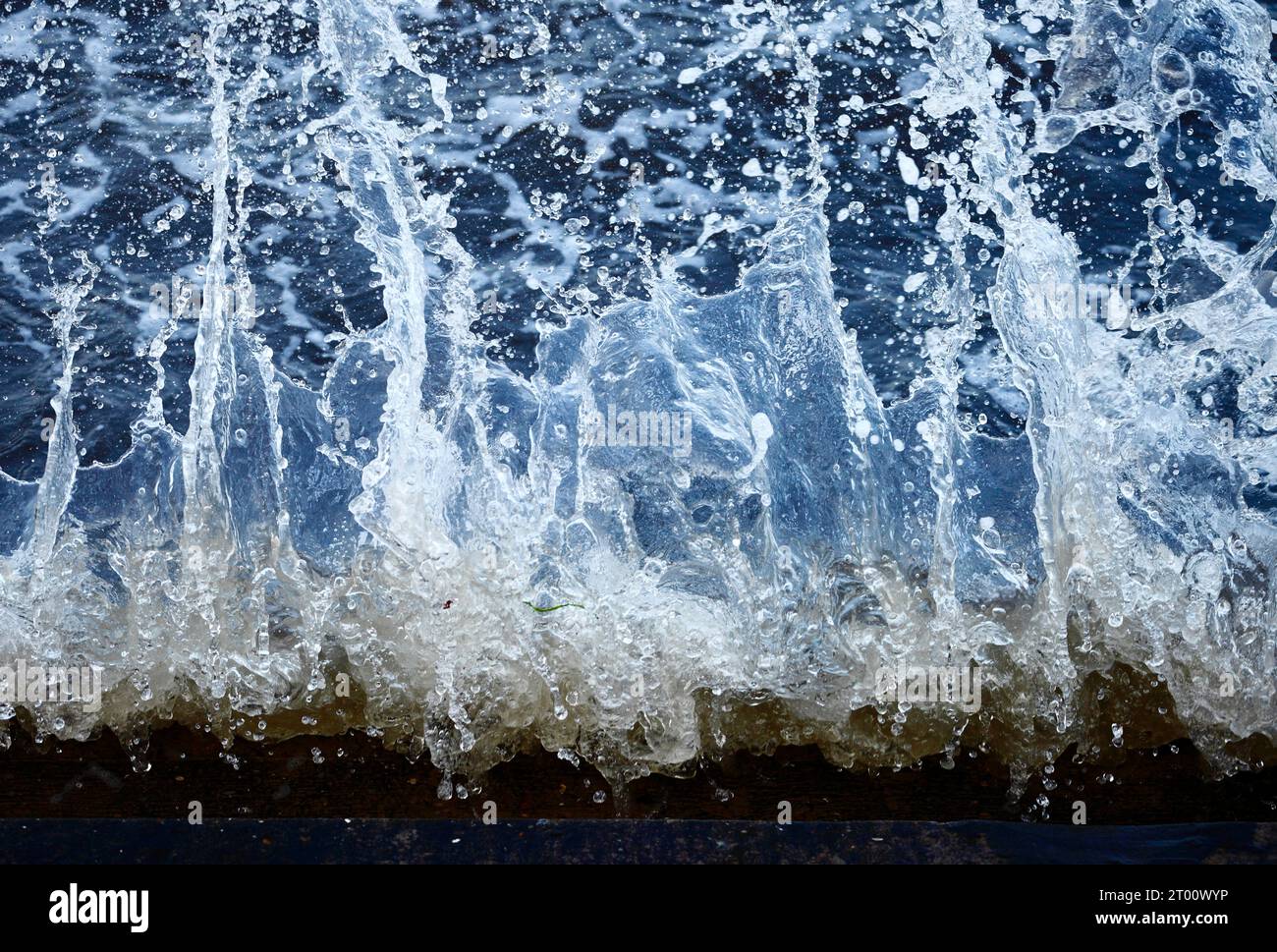 Éclaboussures d'eau de mer contre la paroi de la mer. Banque D'Images