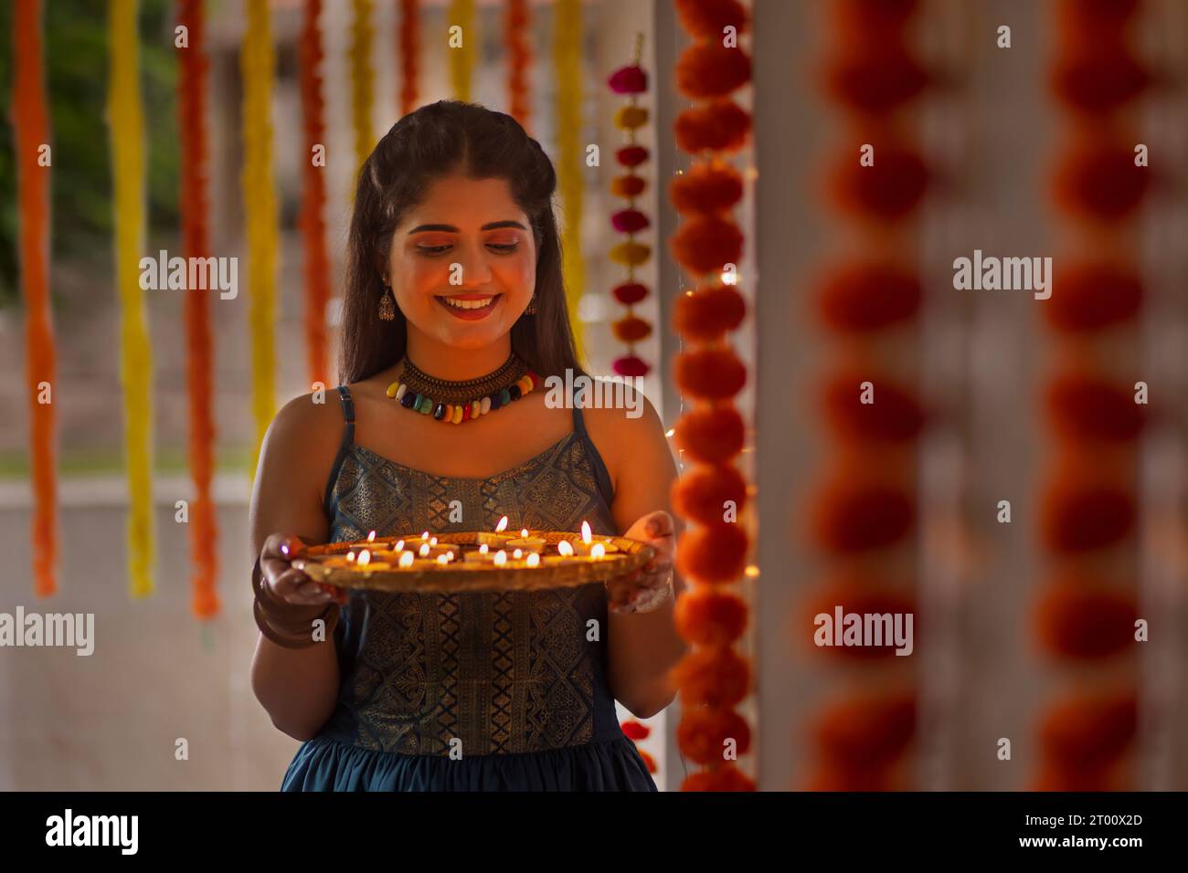 Portrait d'une jeune femme joyeuse tenant une plaque de lampes sur Diwali Banque D'Images
