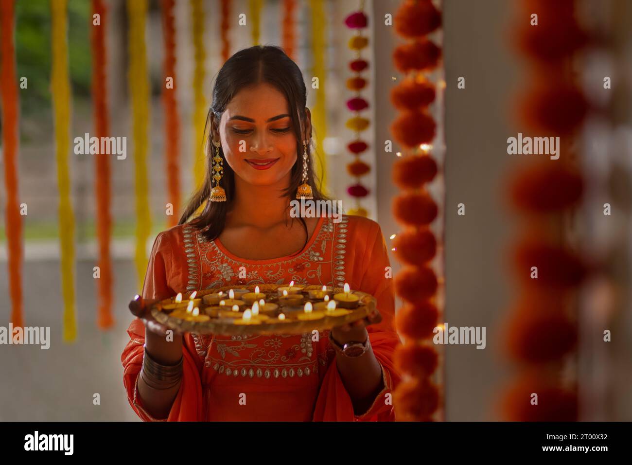 Portrait d'une jeune femme joyeuse tenant une plaque de lampes sur Diwali Banque D'Images
