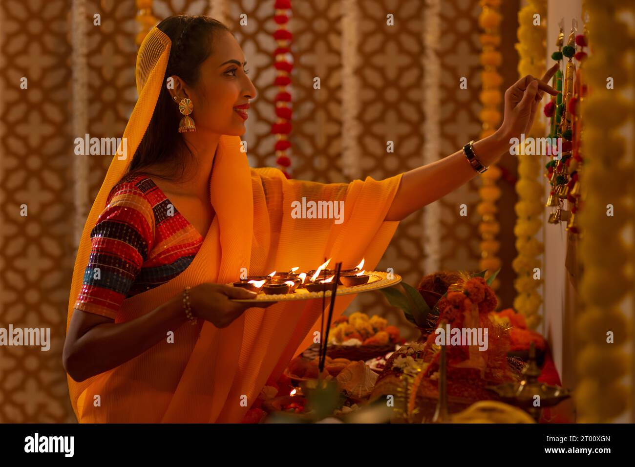 Portrait d'une femme indienne tenant une assiette de diyas et adorant Dieu sur Diwali Banque D'Images