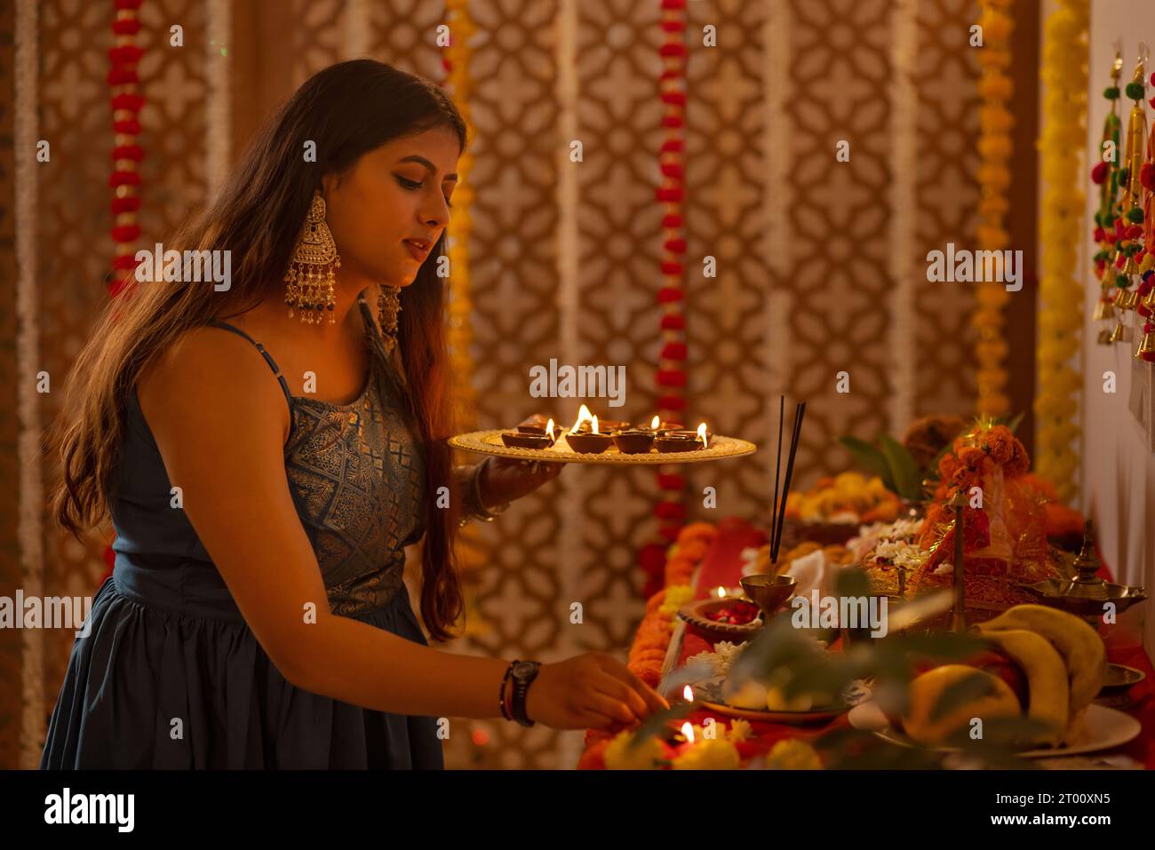 Portrait d'une femme indienne tenant une assiette de diyas et adorant Dieu sur Diwali Banque D'Images