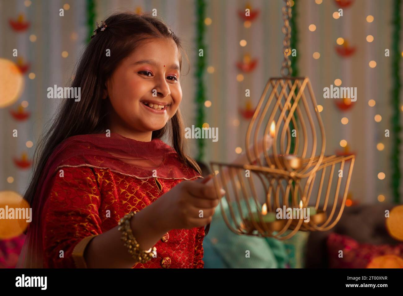 Fille foudre une lampe ( Diya) avec une bougie pendant le festival de Diwali Banque D'Images