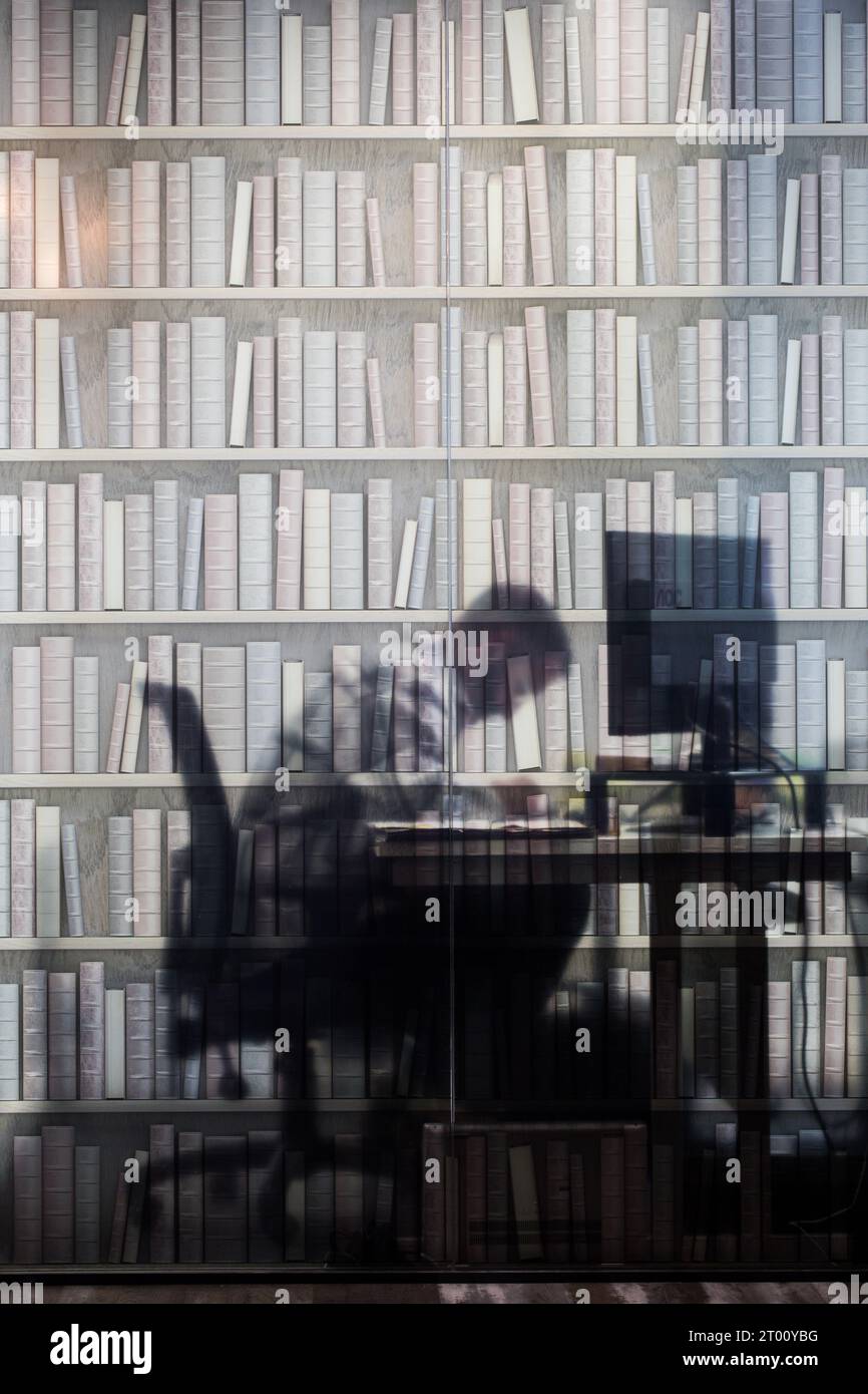 Un homme au travail sur un ordinateur derrière un écran imprimé, dans un immeuble de bureaux à Thornaby, North Yorkshire, Royaume-Uni. 19/07/2023. Photographie : Stuart Boulton. Banque D'Images