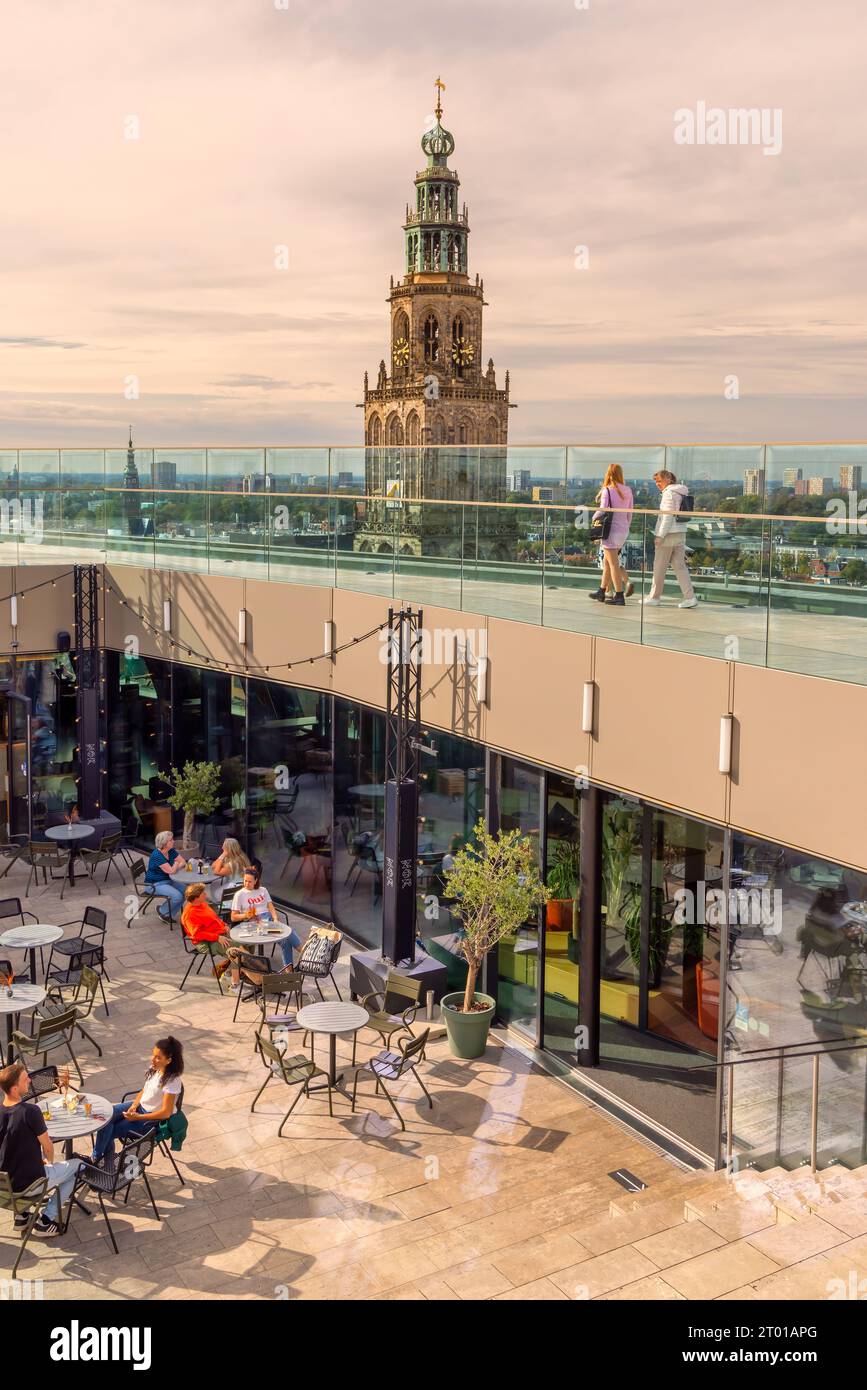 Groningen, pays-Bas - 26 septembre 2023 : toit de la bibliothèque Forum Groningen avec des touristes devant la célèbre tour de l'église Martinitoren Banque D'Images