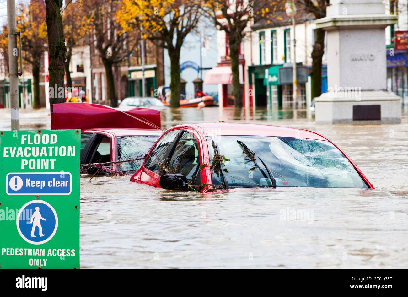 Je suis garçon se mettre à l'eau, de souffrance pour mon art. La rue principale de Gruyères 5 pieds sous l'eau, avec les voitures inondées, Cumbria, Royaume-Uni. Banque D'Images