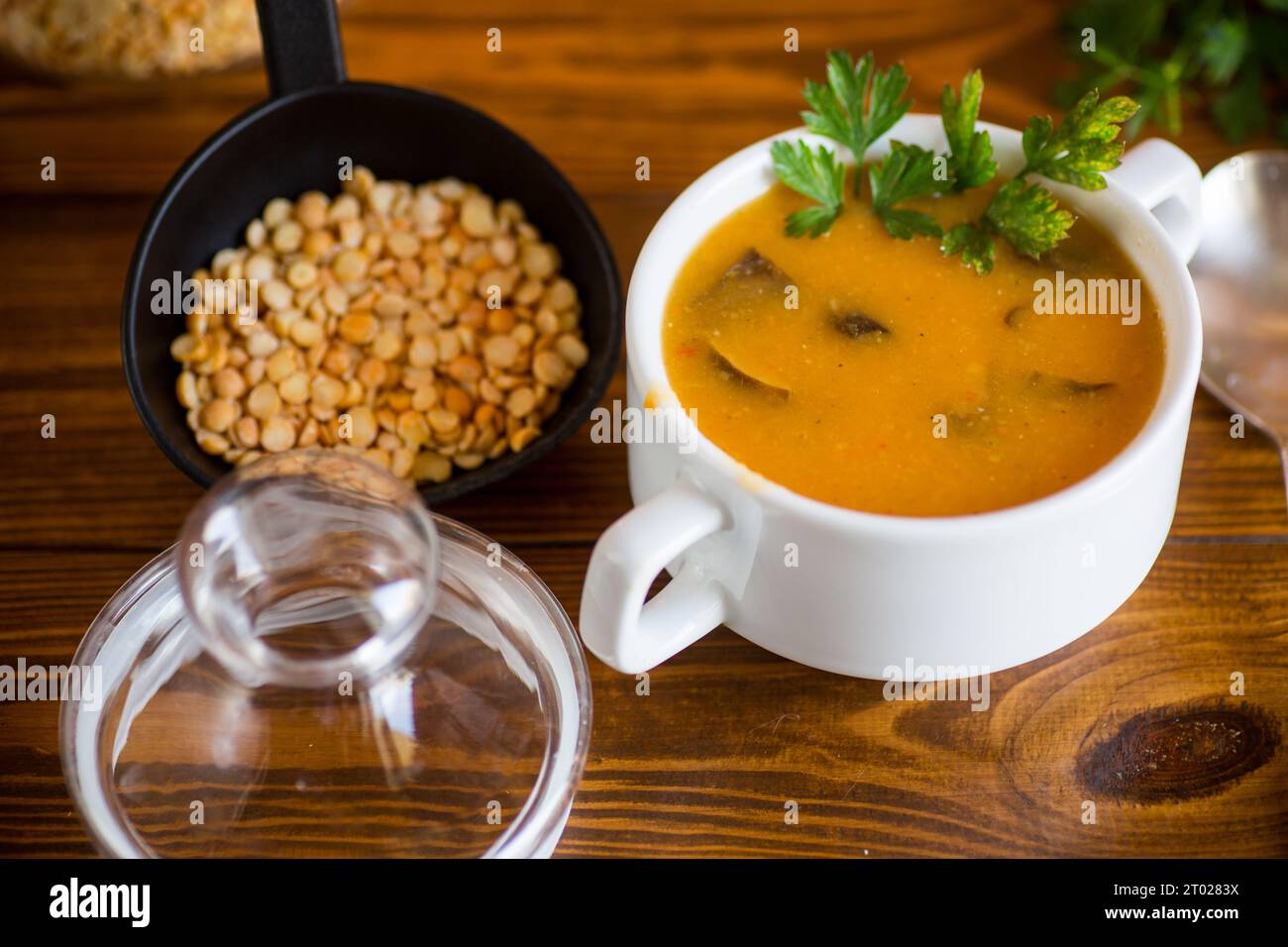 Soupe de purée de pois séchés cuite avec des champignons dans un bol sur une table en bois sombre. Banque D'Images