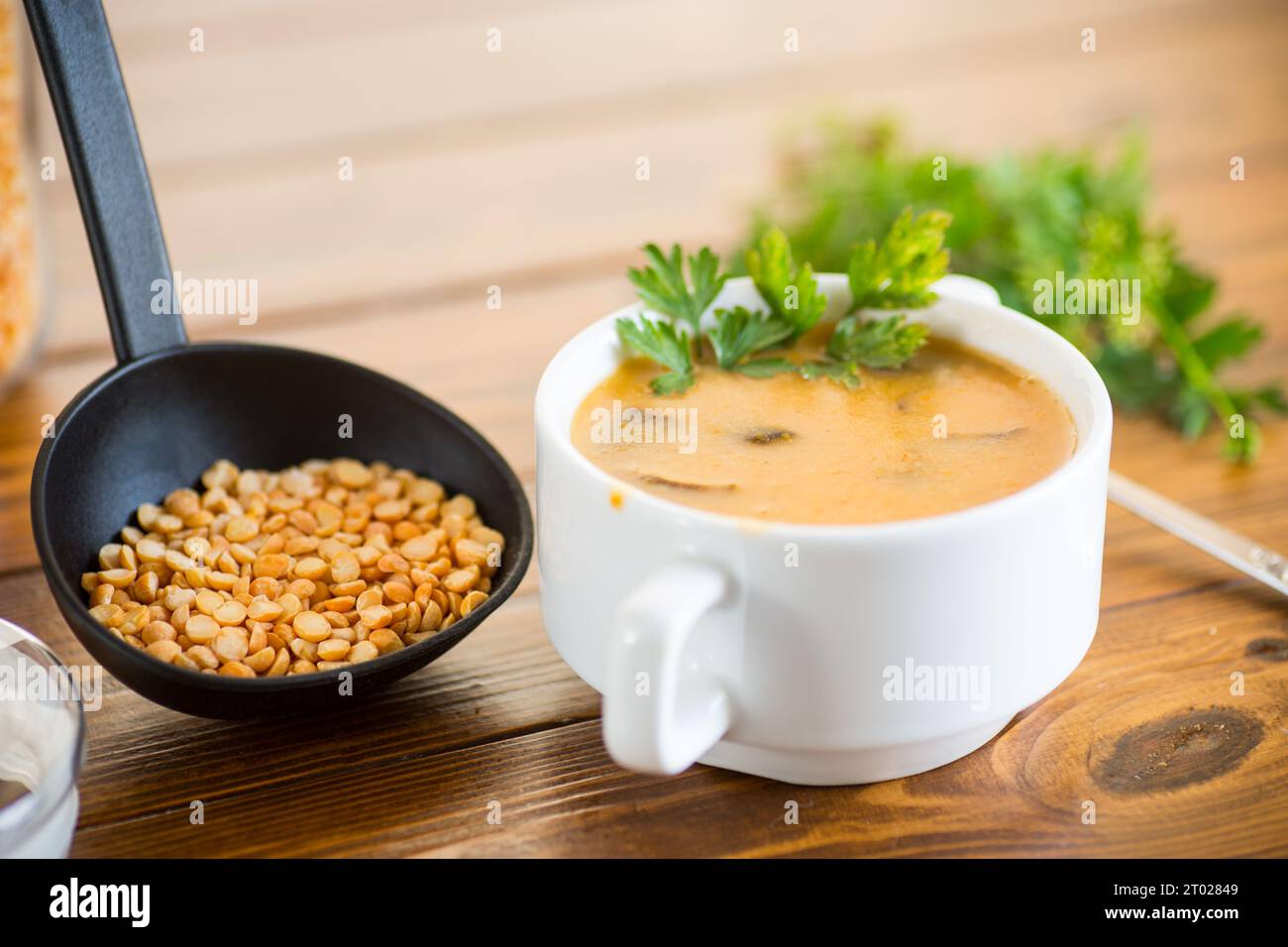 Soupe de purée de pois séchés cuite avec des champignons dans un bol sur une table en bois sombre. Banque D'Images