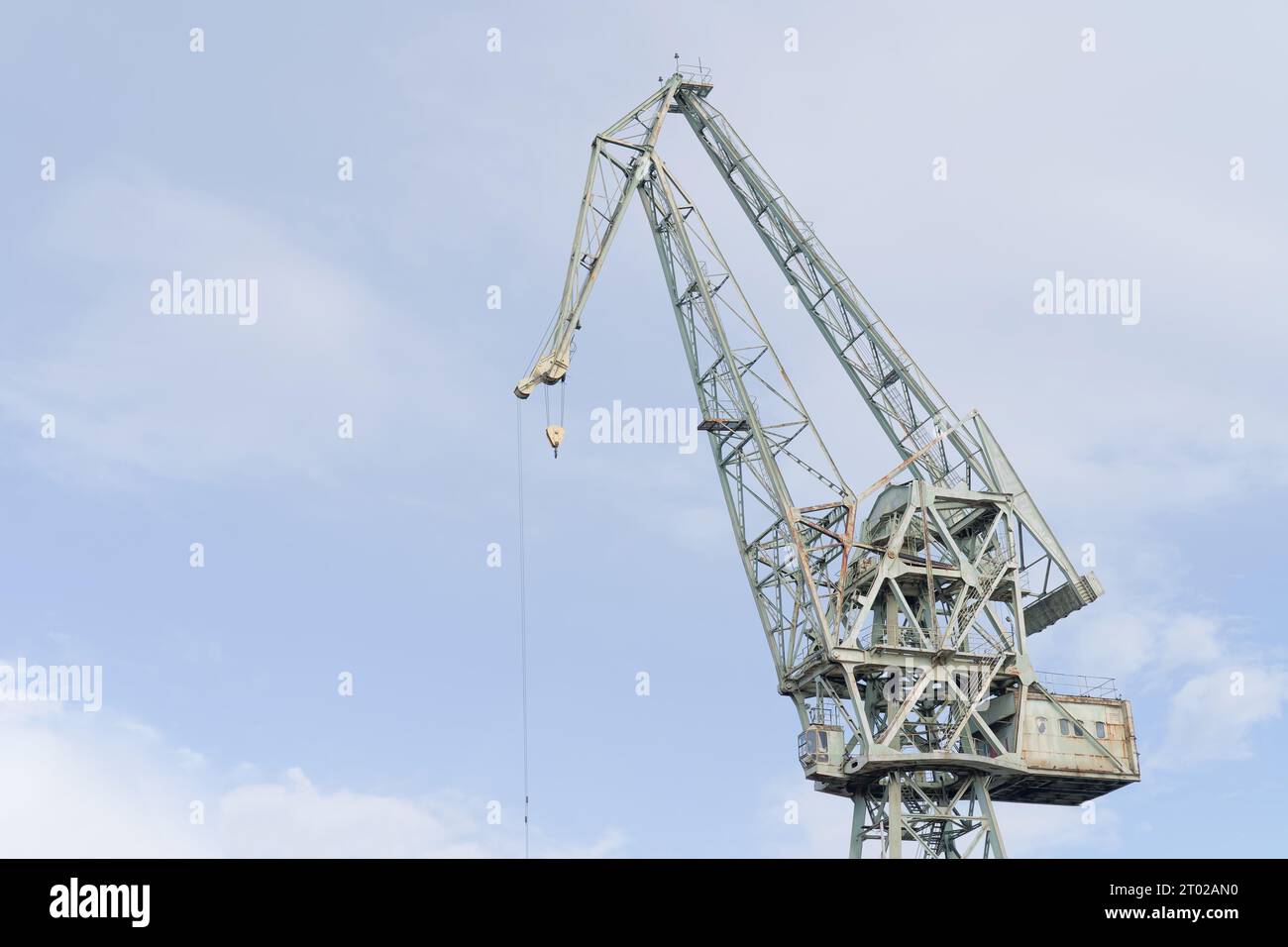 Ancienne grue portuaire contre ciel bleu, symbole du patrimoine industriel dans une ville balnéaire. Banque D'Images