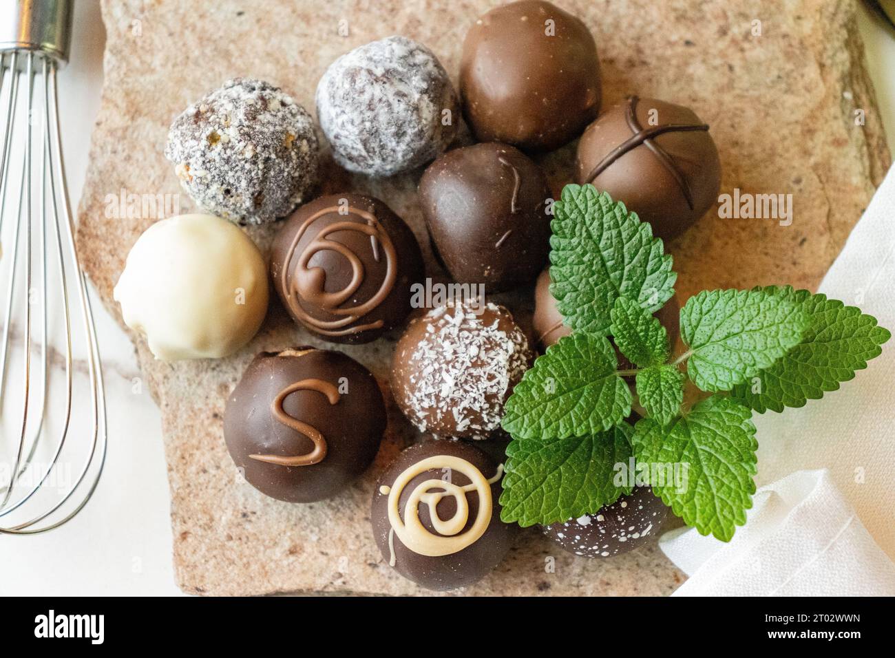 truffes au chocolat sur une pierre avec des feuilles de menthe Banque D'Images