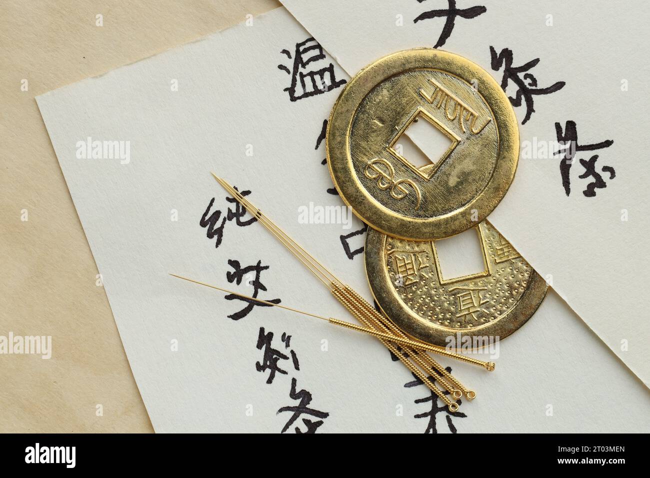 Composition de pose à plat avec des aiguilles d'acupuncture et des pièces chinoises sur papier Banque D'Images