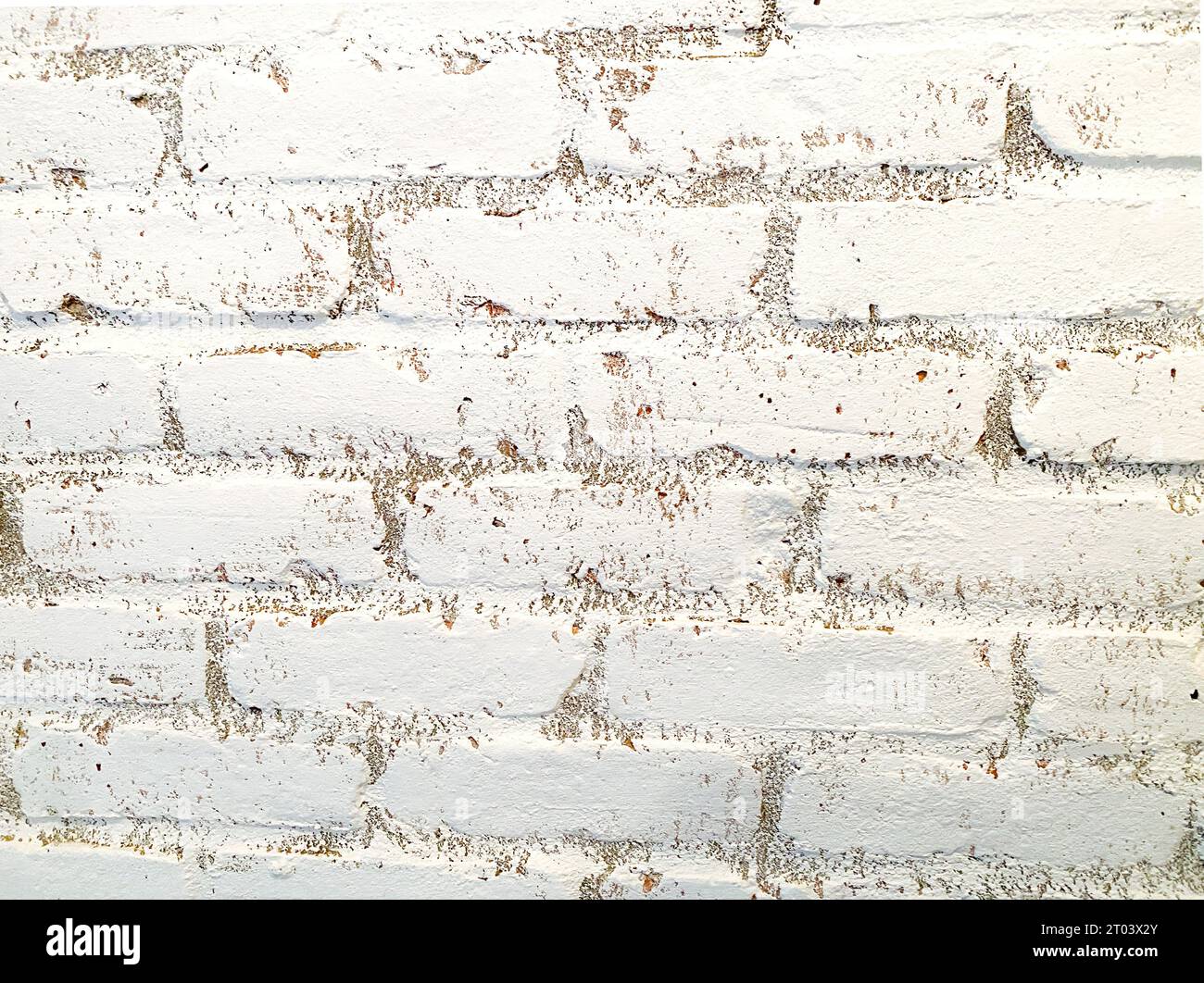 Mur de briques blanches en gros plan. Mur intérieur en briques, peint en blanc avec un peu de saleté et imparfaite, texture rugueuse, usée par le temps. Convient comme arrière-plan. Banque D'Images