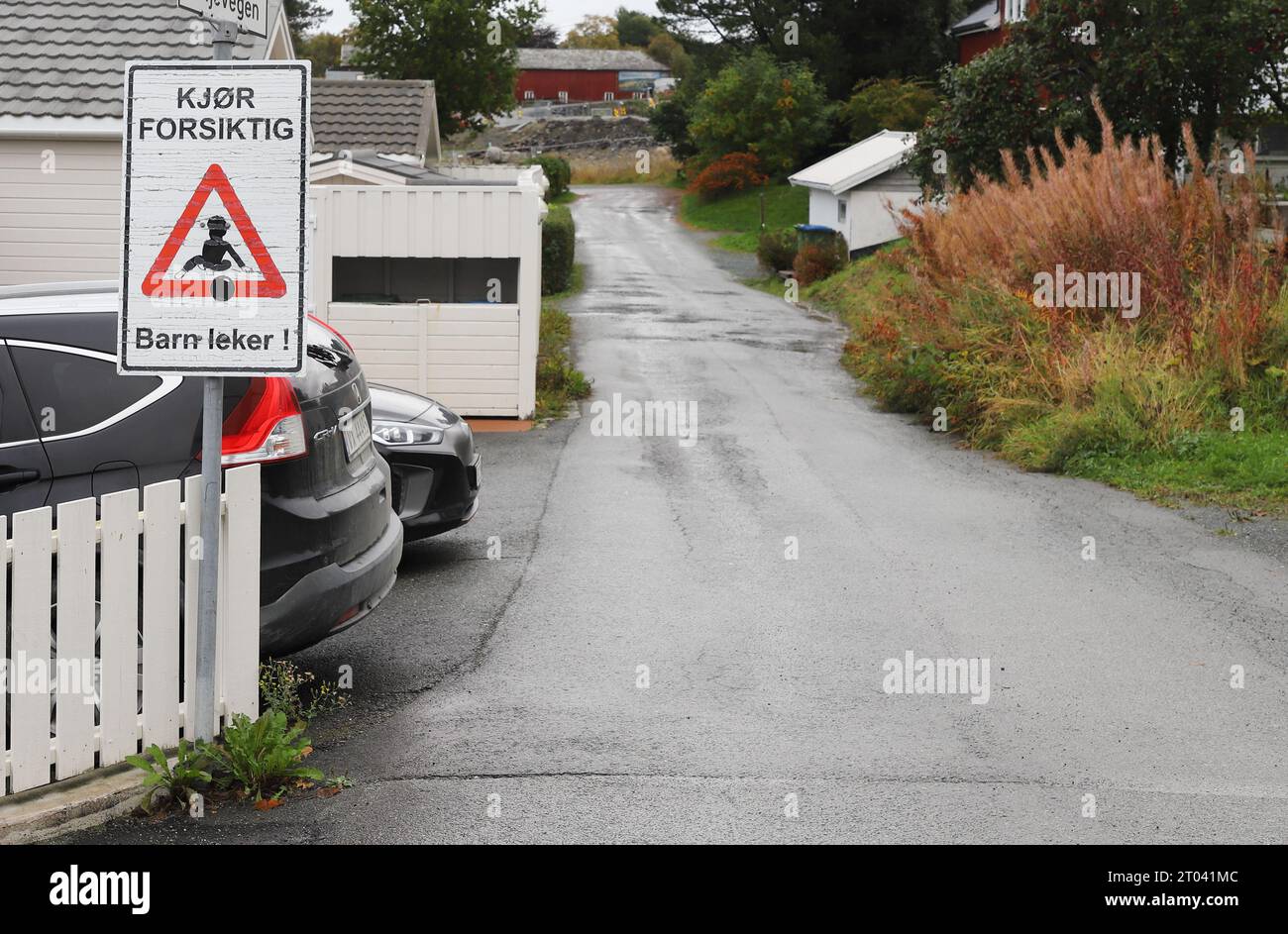 Vikhammer, Norvège - 30 septembre 2023 : panneau d'information en norvégien dans un quartier résidentiel avec des maisons unifamiliales exhorte à conduire prudemment parce que Banque D'Images