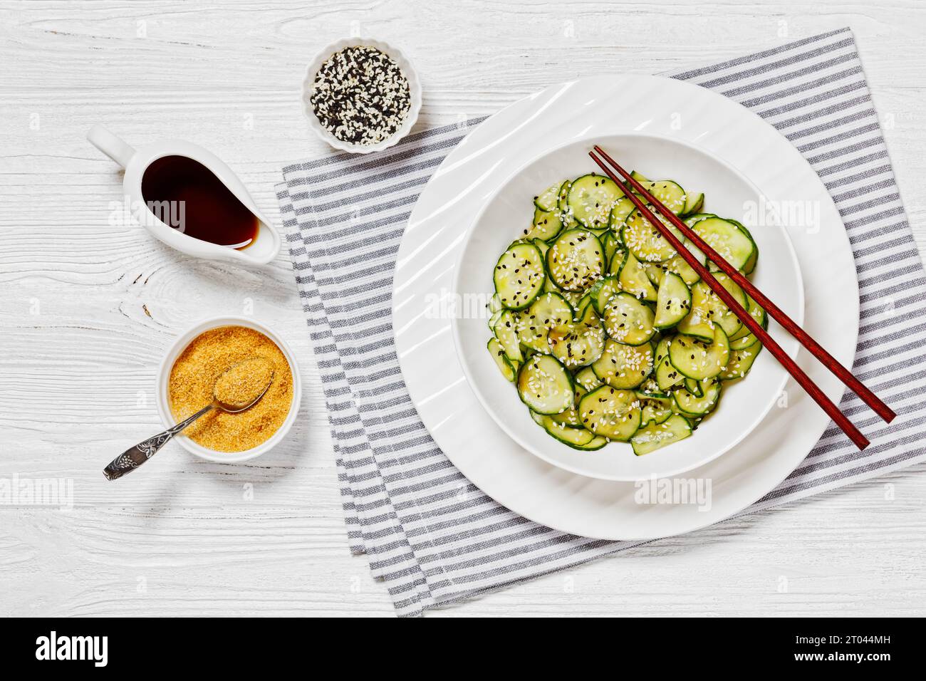 Sunomono, salade japonaise de concombres, tranches de concombres avec sauce asiatique de soja, vinaigre de riz, huile de sésame et sucre dans un bol blanc avec baguettes Banque D'Images