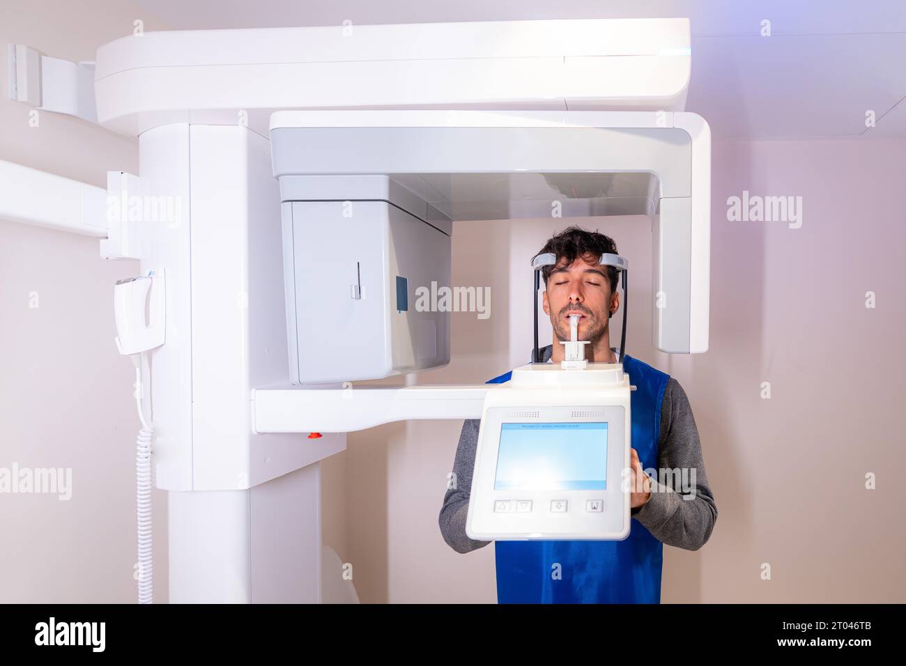 Vue de face d'un homme les yeux fermés dans un appareil radiographique dentaire Banque D'Images