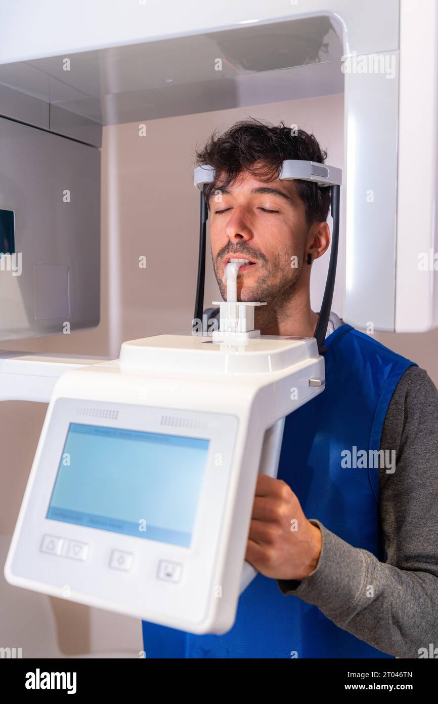 Photo verticale d'un homme les yeux fermés dans un appareil radiographique dentaire Banque D'Images