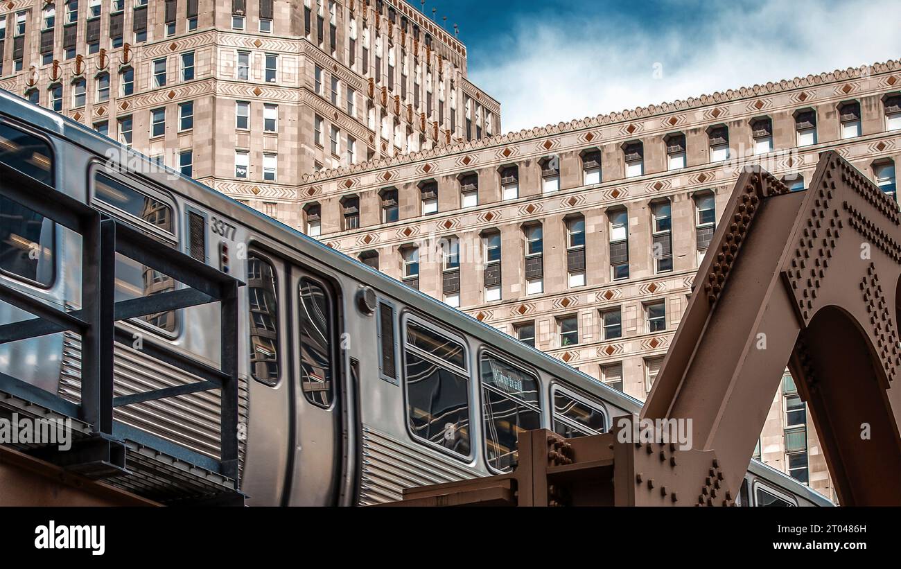 Un train classique est capturé à mi-parcours, garé sur un pont avec de larges fenêtres offrant une vue panoramique sur le paysage environnant Banque D'Images