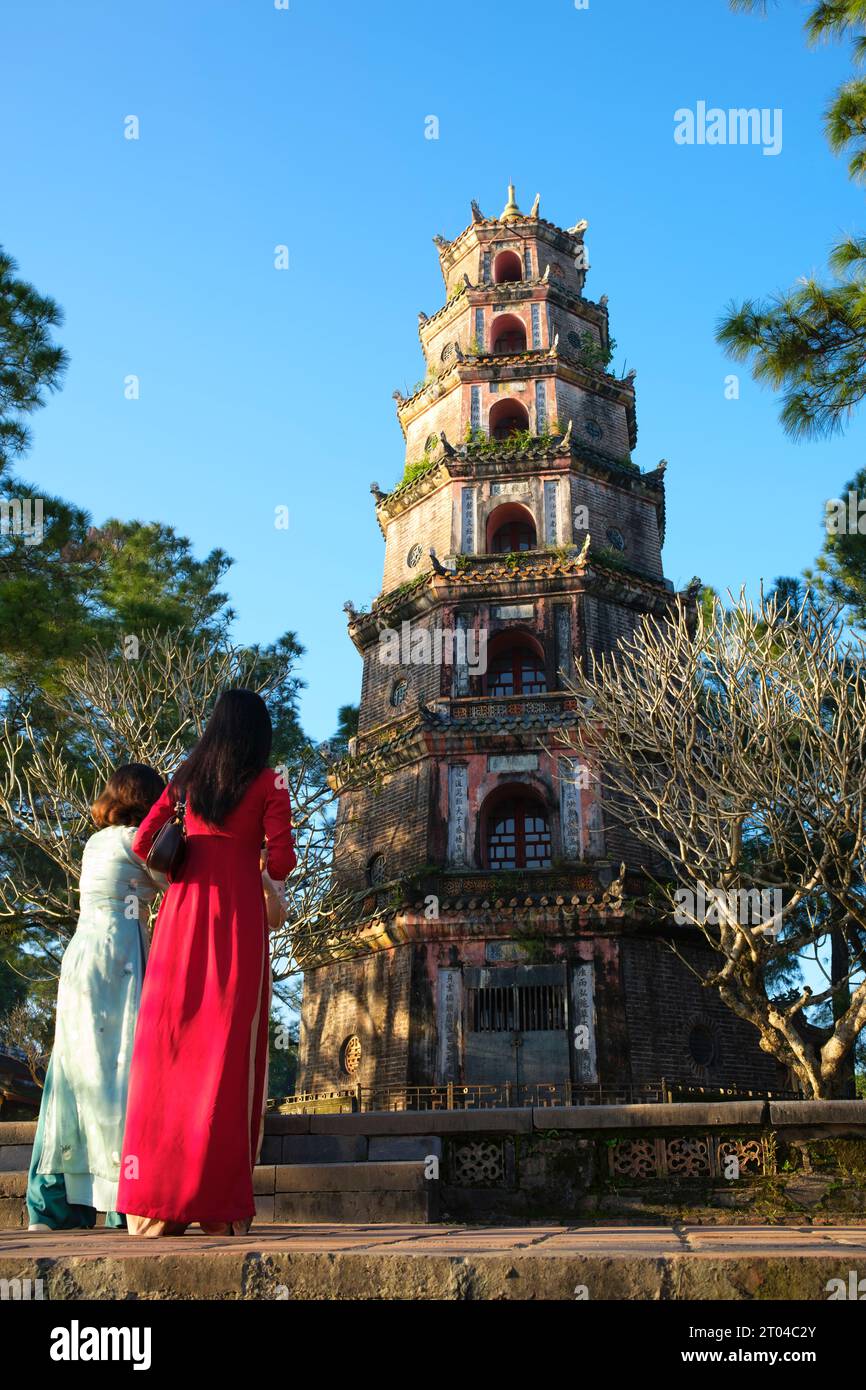 Vietnam : femmes dans le traditionnel vietnamien ao dai (« robe longue »), Pagode Thien Mu, Hué. La pagode Thien Mu a été construite en 1601 EC sous Nguyen Hoang, le gouverneur de la province de Thuan Hoa, maintenant connue sous le nom de Hue. Bien qu'il ait juré fidélité à la dynastie le à Hanoi, Nguyen Hoang dirigea effectivement Thuan Hoa en tant qu'État indépendant dans le centre du Vietnam. La pagode a sept étages et est la plus haute du Vietnam, et est souvent le sujet de rimes folkloriques et de poésie sur Hué, qui était la capitale impériale du Vietnam entre 1802 et 1945. Banque D'Images