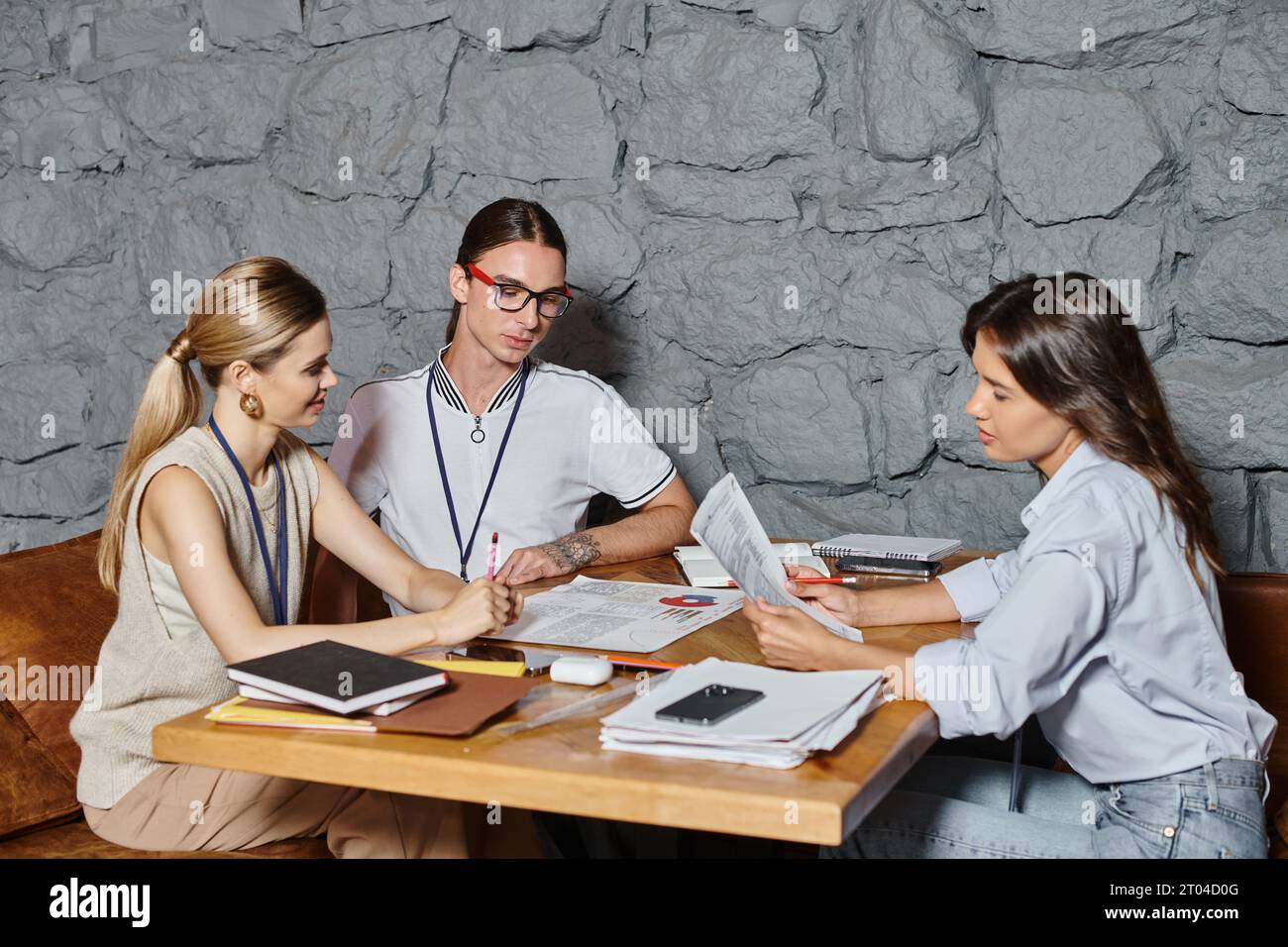 trois collègues en tenue formelle travaillant dur assis à table discutant du travail, du concept de coworking Banque D'Images