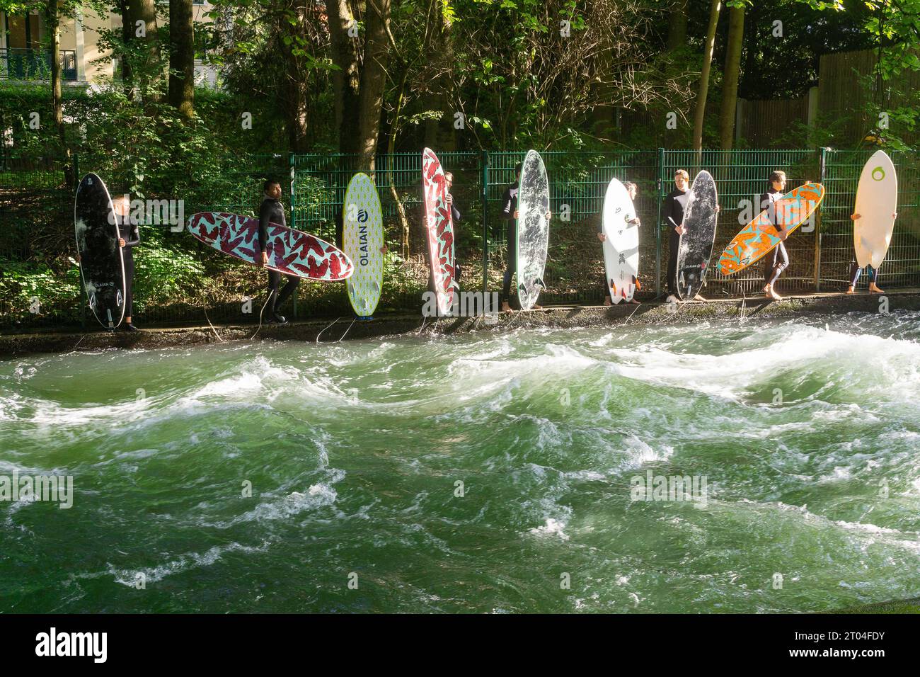Munich Allemagne - les surfeurs font la queue sur la rivière Eisbach dans le parc public English Garden. Banque D'Images