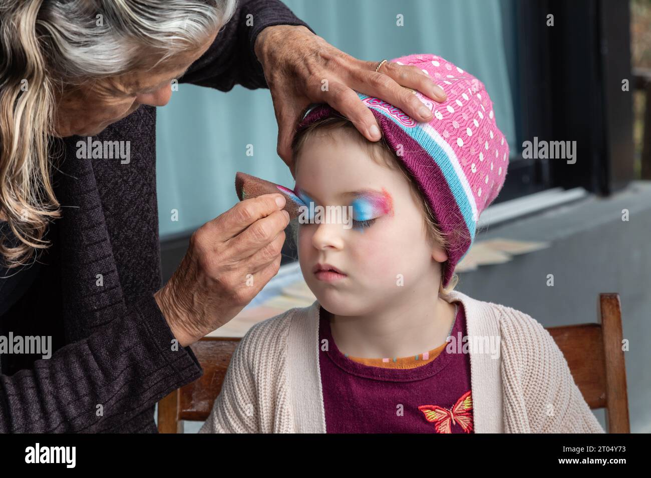 Dans un moment fantaisiste de pur délice, une petite fille se transforme en licorne magique avec son visage peint Banque D'Images