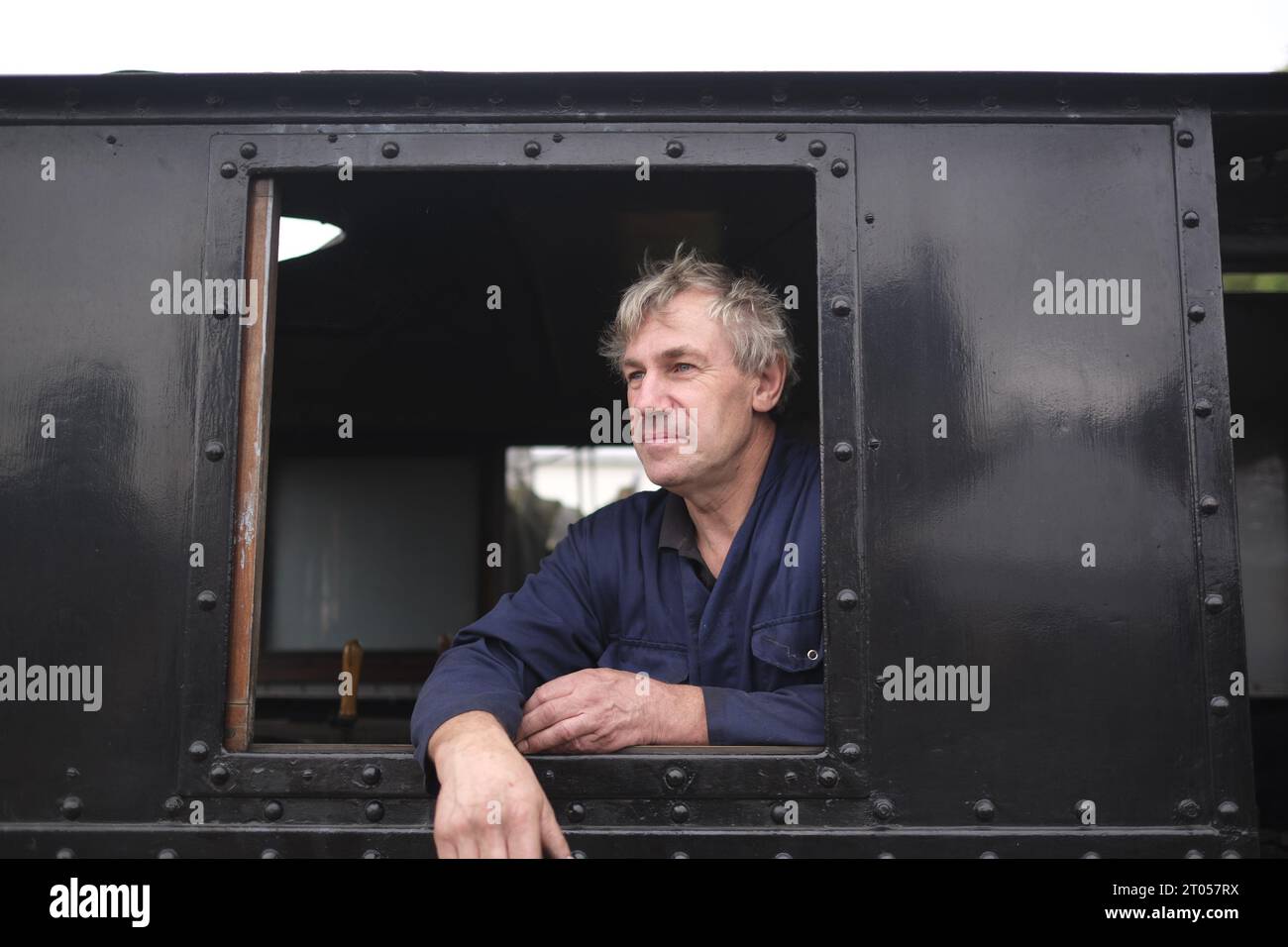 Cholsey & Wallingford Railway, Oxfordshire, conducteur de train britannique penché par la fenêtre de sa locomotive à vapeur, restauration du patrimoine, chemin de fer du patrimoine Banque D'Images