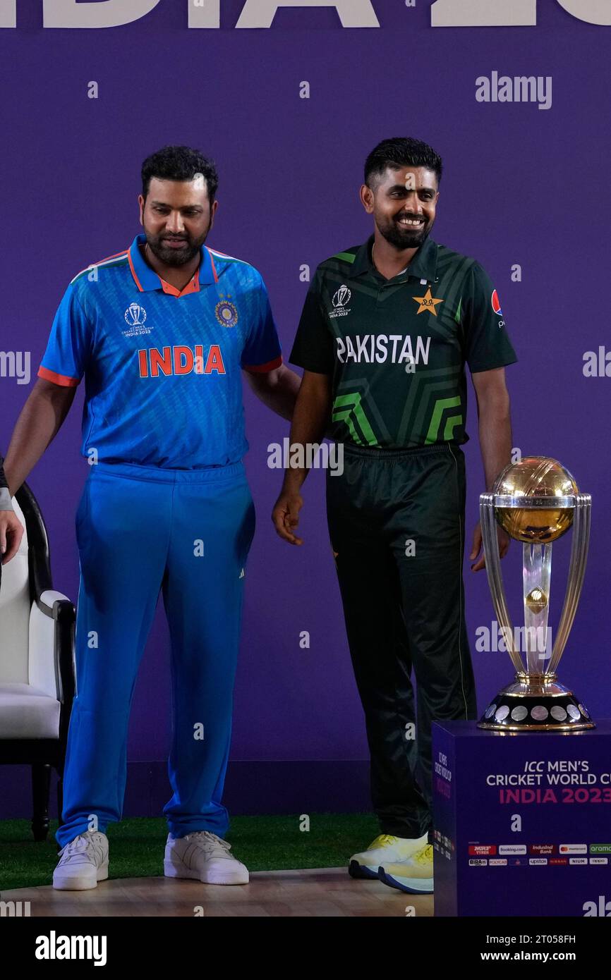 India's captain Rohit Sharma, left, shares a light moment with Pakistan's captain Babar Azam as they pose with the ICC Men's Cricket World Cup trophy in Ahmedabad, India, Wednesday, Oct. 4, 2023.(AP Photo/Rafiq Maqbool) Banque D'Images