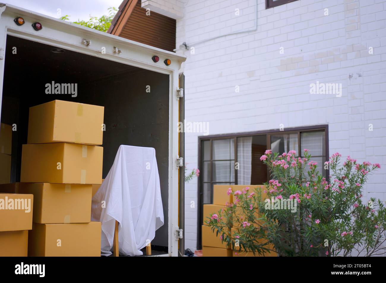 Le livreur déplace les objets à la maison. Concept de service et de livraison. Banque D'Images