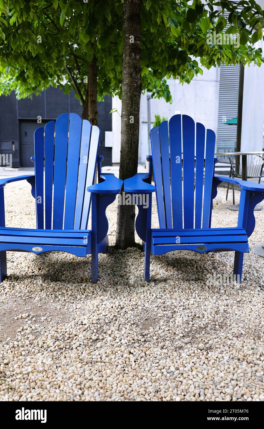 Blue Muskoka Adirondack chaises dans un parc Banque D'Images