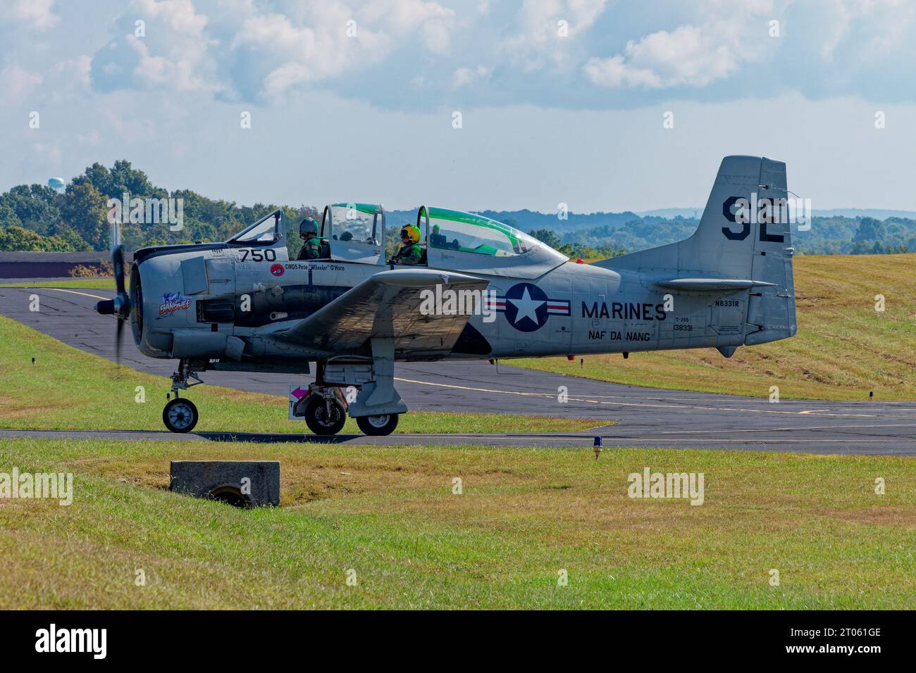 Un pilote et un copilote roulant sur la piste dans un spectacle aérien volant un avion vintage Marines par une journée brumeuse ensoleillée à Crossville, Tennessee Banque D'Images