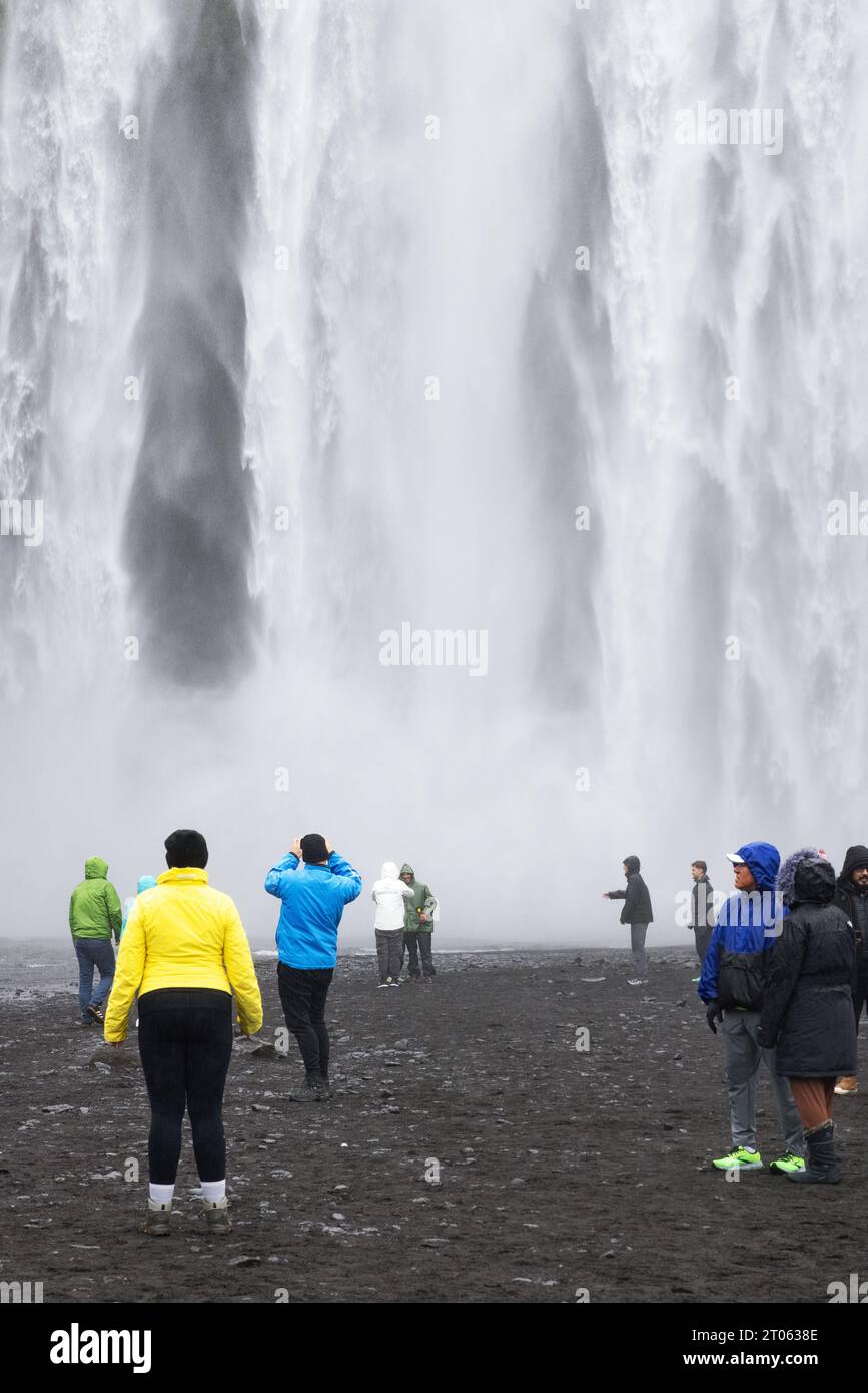 Cascade d'Islande - touristes à la cascade de Skogafoss, l'une des nombreuses cascades de la tournée de la côte sud de l'Islande, Islande, Europe. Voyage Banque D'Images