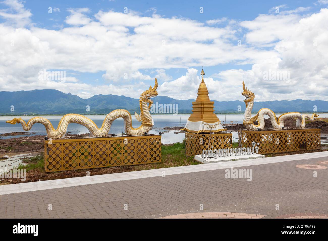 Phayao Town point de repère dans le nord de la Thaïlande. Statue de Naga et stupa doré sur le lac Phayao et le fond des montagnes. Banque D'Images