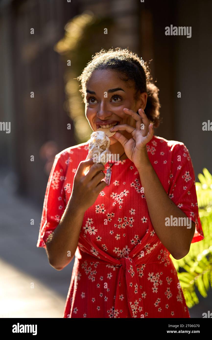 Jeune femme latine mangeant une glace dehors Banque D'Images