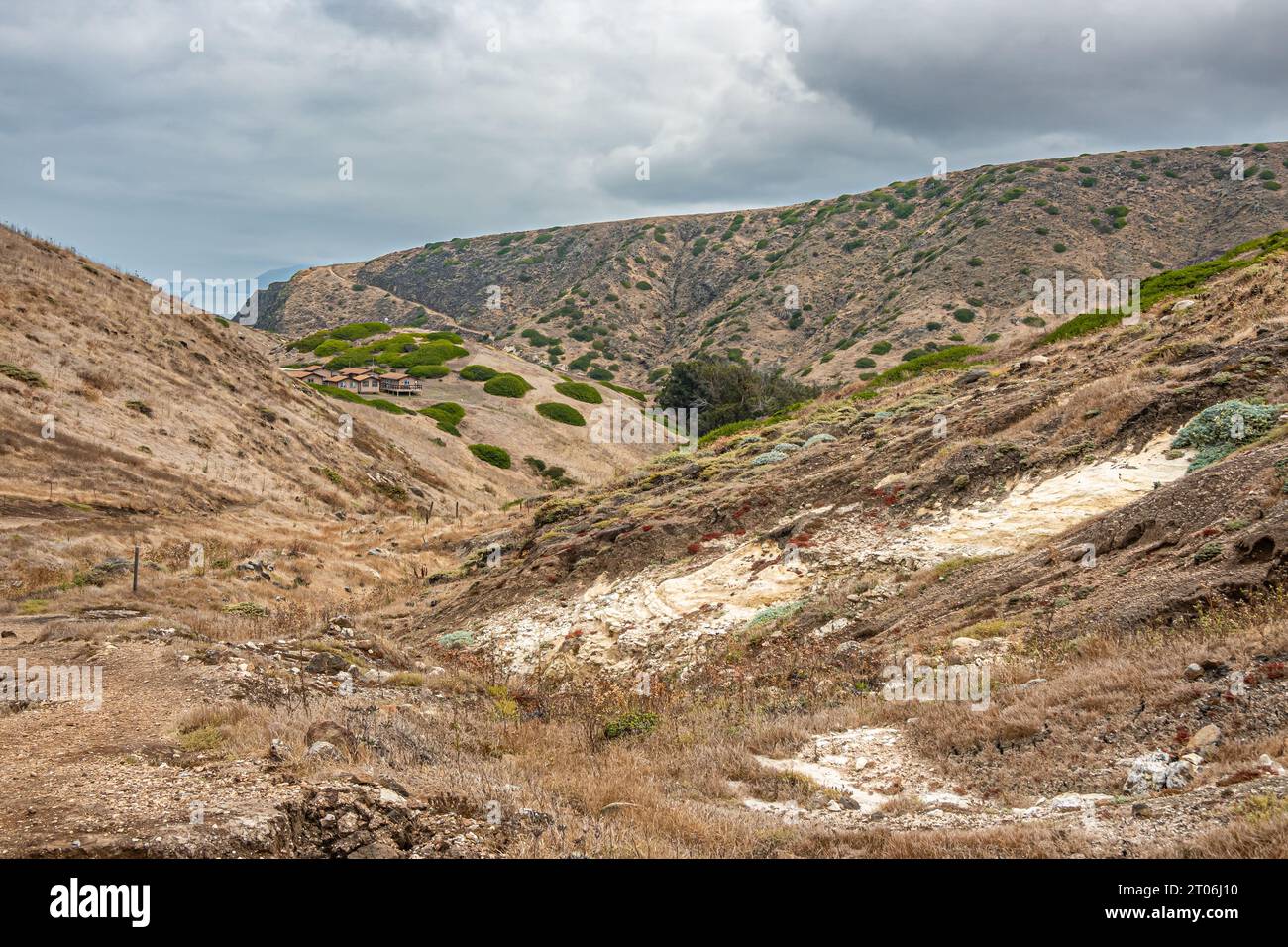 Santa Cruz Island, CA, USA - 14 septembre 2023 : paysage sec accidenté avec quelques taches vertes et un grand site de pierre dure blanc exposé sous s. Banque D'Images