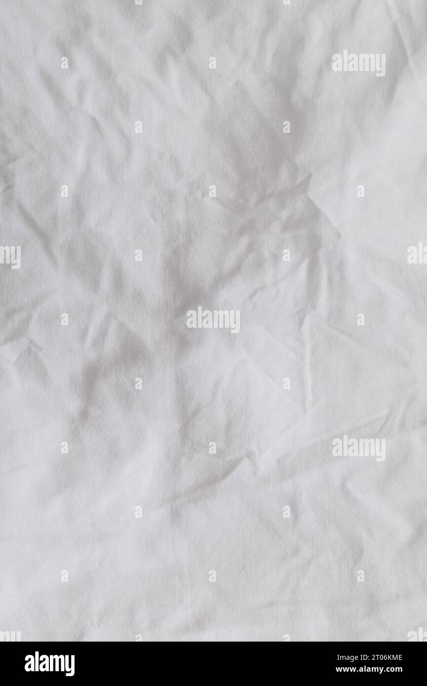 Gros plan d'un drap de literie désordonné. Drap de literie froissé pour fond et décoration. Fond minimal et concept de texture. Pose à plat, vue de dessus. Banque D'Images