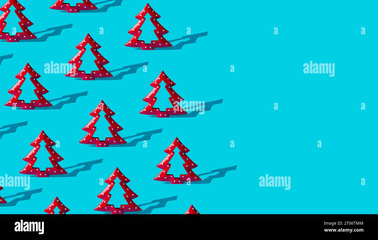 Fond de motif de composition minimale d'arbres de Noël rouges sur bleu clair avec espace de copie. Concept du nouvel an ou de Noël. Vacances d'hiver tendance pat Banque D'Images