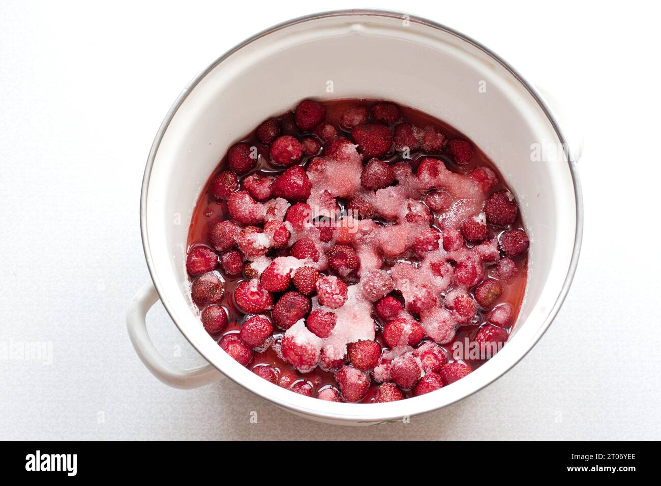 L'étape de faire de la confiture de fraises maison. Les baies mûres sont saupoudrées de sucre dans une casserole. Heure d'été pour la mise en conserve de confiture de baies. vue de dessus Banque D'Images