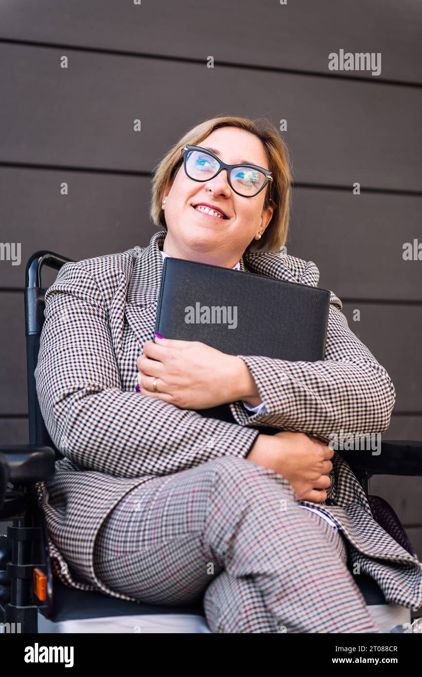 femme d'affaires utilisant le dossier de maintien de fauteuil roulant Banque D'Images