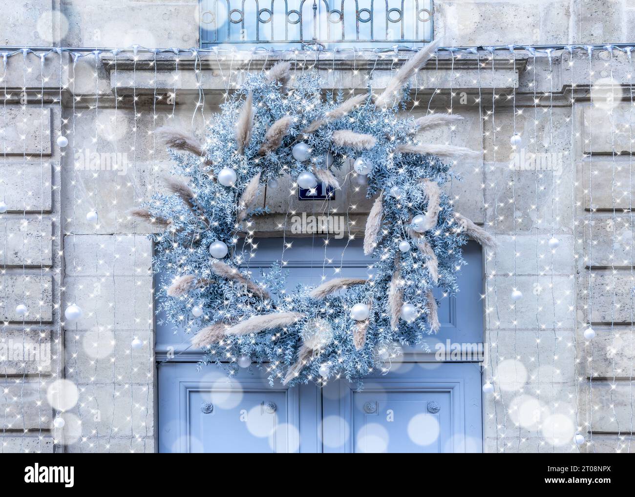 Couronne de Noël rustique bleu et blanc et lumières sur une porte d'entrée en France Banque D'Images