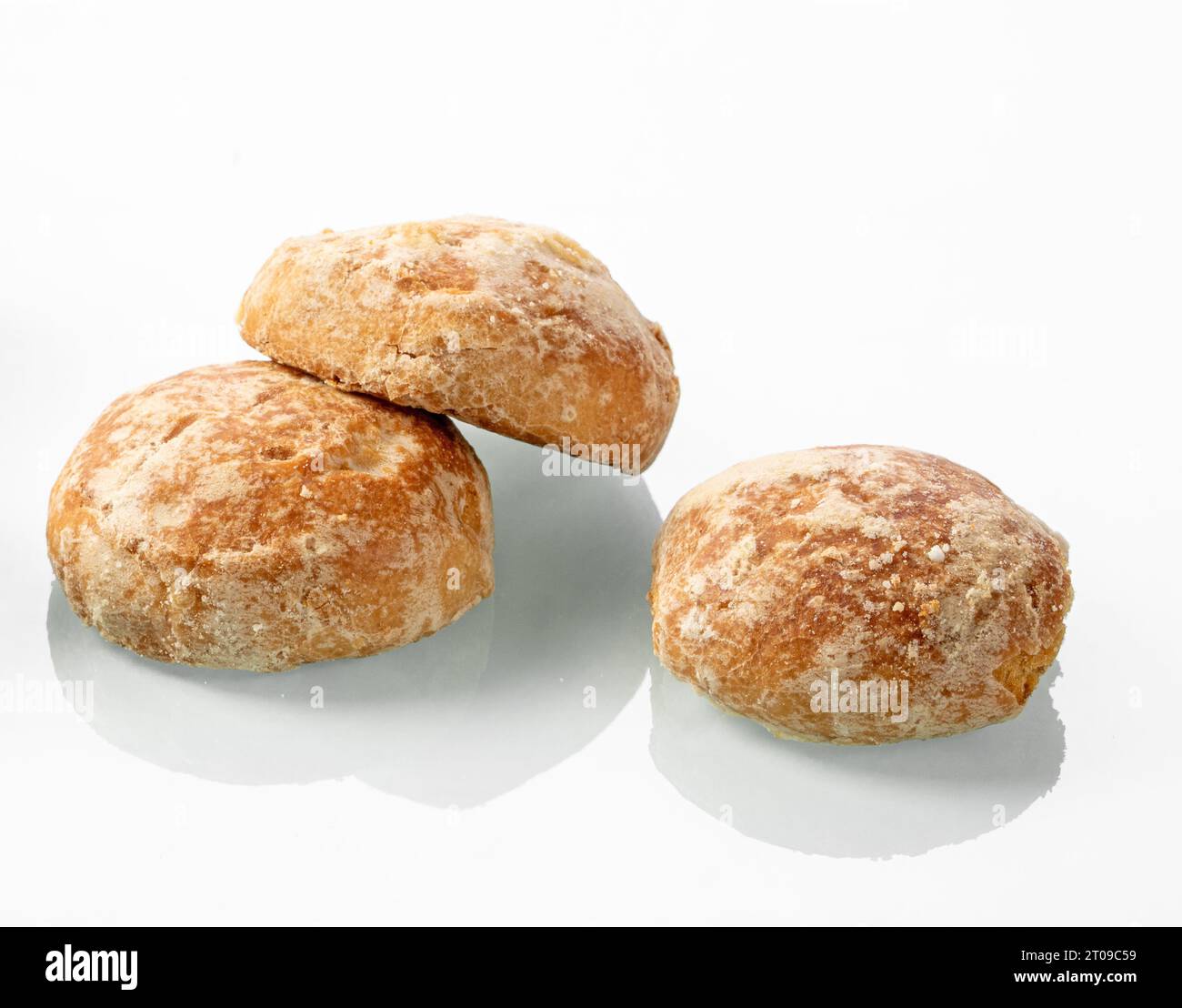 Petits pains sucrés russes en pain d'épice sur un fond de miroir blanc. Trois pains d'épices ont un reflet contrasté Banque D'Images