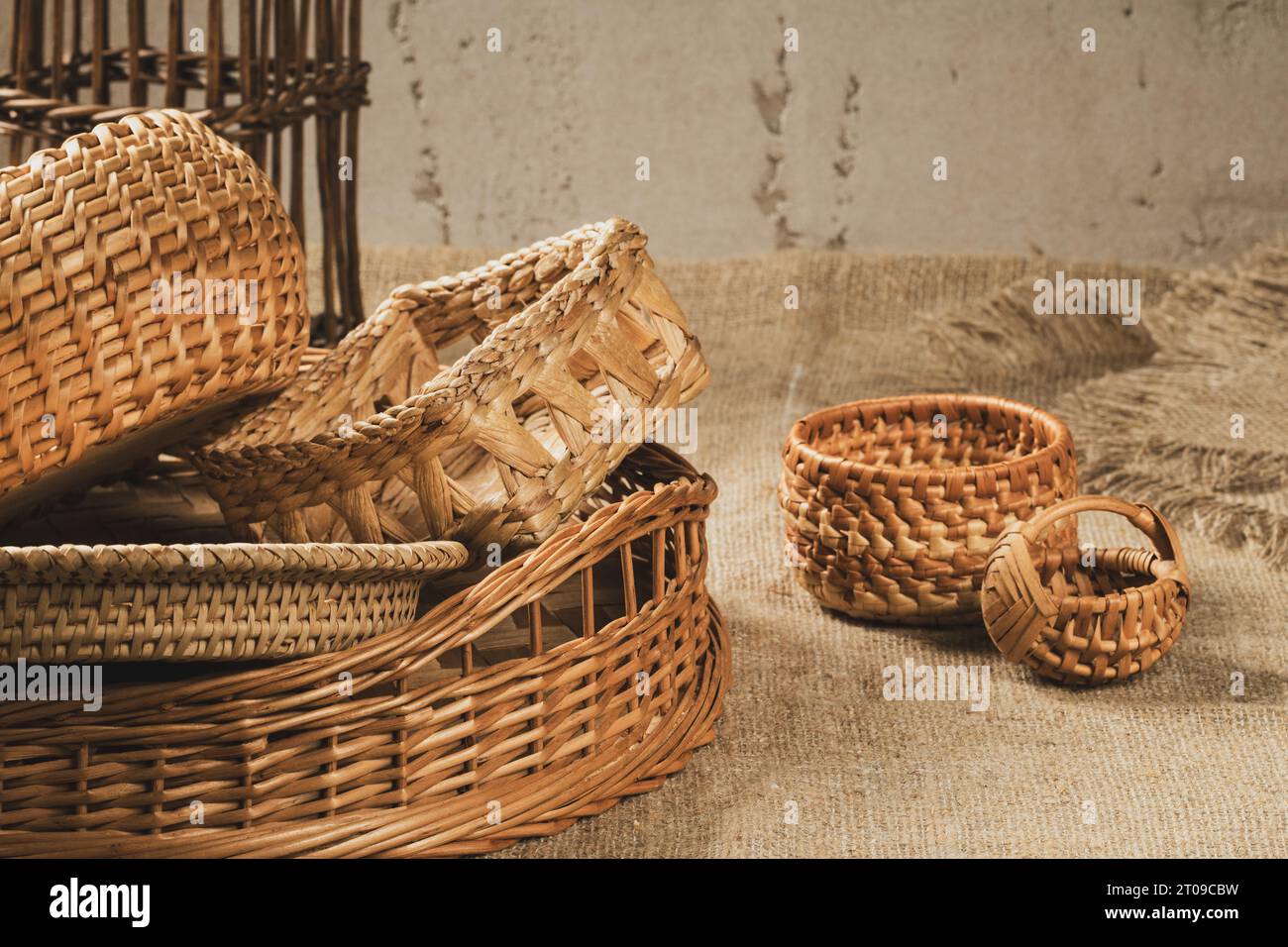 Un groupe de paniers de différentes formes tissés à partir de matériaux naturels sur une nappe en toile de jute. Banque D'Images