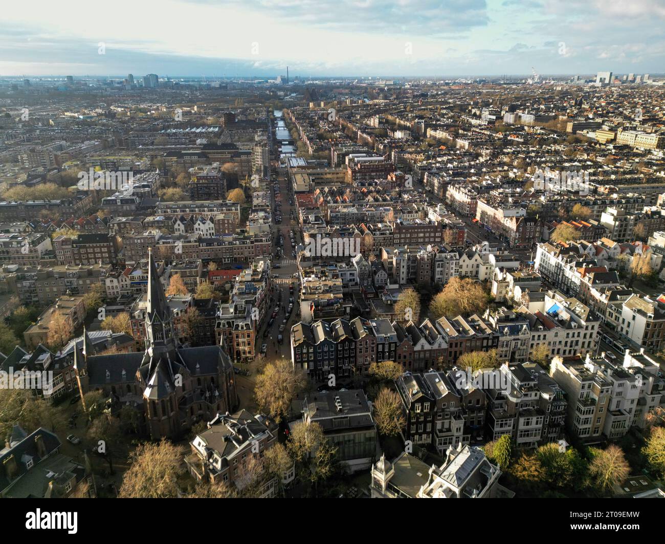 Vue aérienne panoramique de la ville d'Amsterdam avec des bâtiments résidentiels et des arbres verts sous un ciel nuageux Banque D'Images