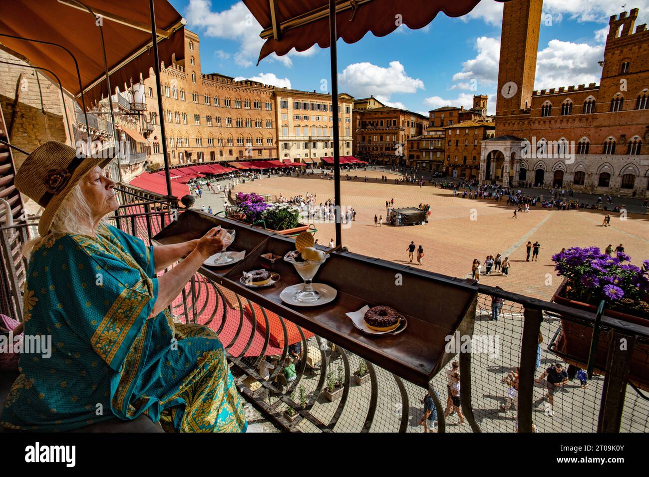 Sienne Toscane Italie septembre 2023 modèle libéré Femme apprécie la crème glacée et gâteau donnant sur la Piazza del Campo et la Tour Mangia (Torre de Banque D'Images