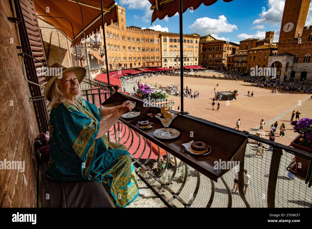 Sienne Toscane Italie septembre 2023 modèle libéré Femme apprécie la crème glacée et gâteau donnant sur la Piazza del Campo et la Tour Mangia (Torre de Banque D'Images
