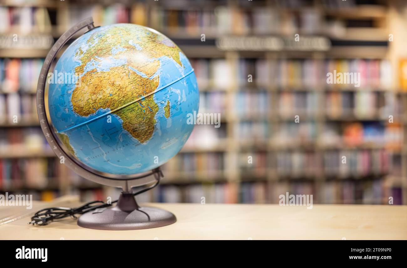 Un globe comme équipement scolaire placé sur une étagère dans la bibliothèque de l'école. Espace pour le texte. Banque D'Images